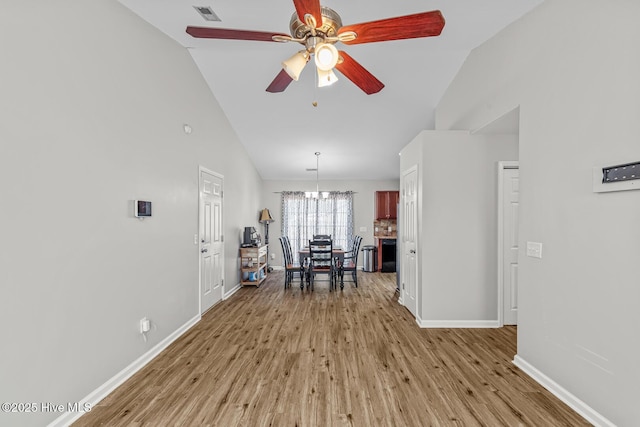 interior space featuring light hardwood / wood-style floors, ceiling fan with notable chandelier, and lofted ceiling