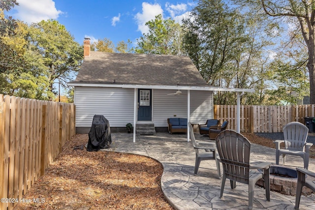 rear view of property featuring a patio, ceiling fan, and an outdoor fire pit