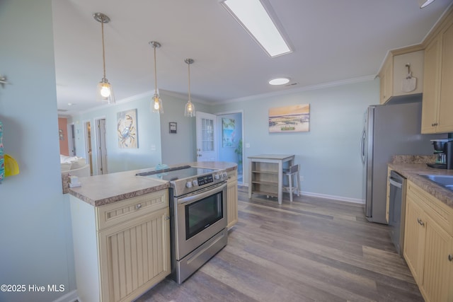 kitchen with stainless steel appliances, crown molding, sink, light hardwood / wood-style flooring, and hanging light fixtures