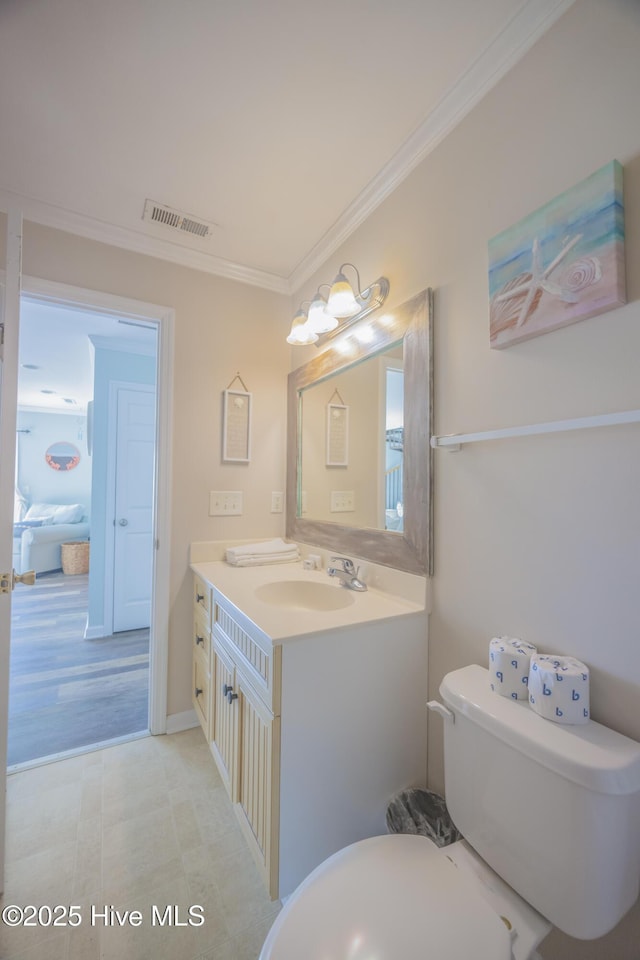 bathroom with vanity, toilet, and ornamental molding