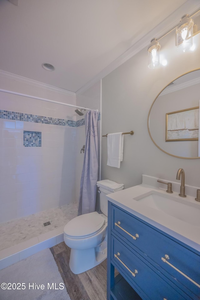 bathroom featuring a shower with curtain, vanity, crown molding, wood-type flooring, and toilet