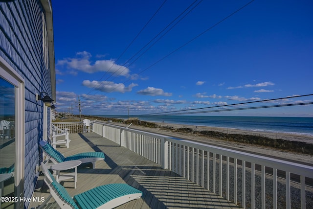 balcony featuring a view of the beach and a water view