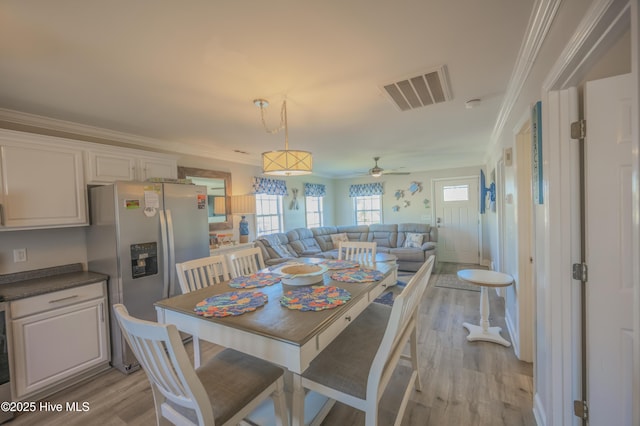 dining space featuring ceiling fan, light hardwood / wood-style floors, and ornamental molding