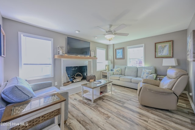 living room with ceiling fan and light hardwood / wood-style floors