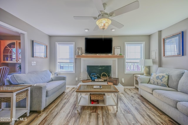 living room with light hardwood / wood-style floors, plenty of natural light, and ceiling fan