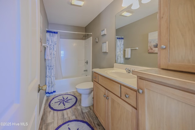 full bathroom with hardwood / wood-style floors, vanity, shower / bath combo, and toilet