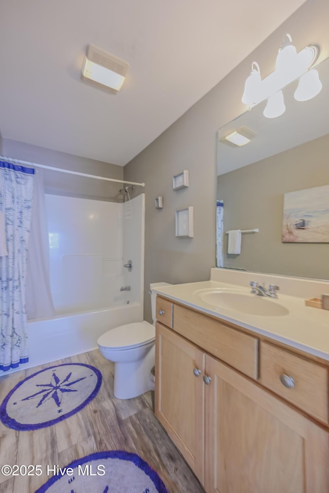 full bathroom featuring shower / bath combo with shower curtain, vanity, wood-type flooring, and toilet