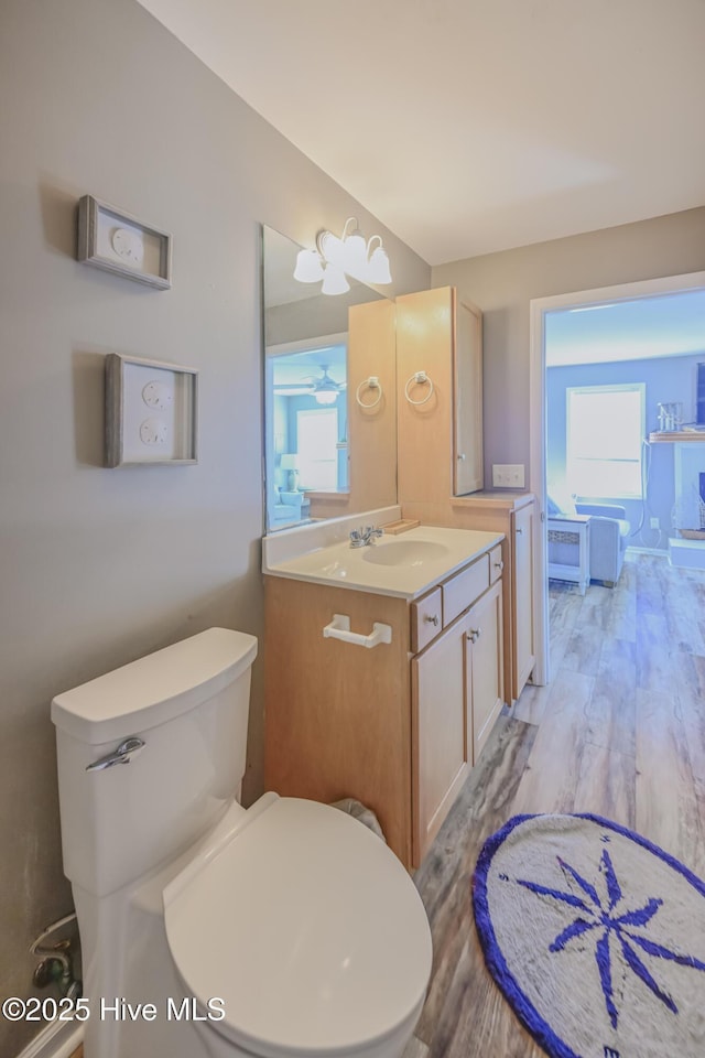 bathroom featuring hardwood / wood-style floors, vanity, ceiling fan, and toilet