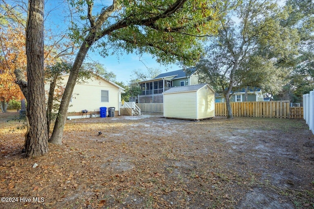 view of yard with a sunroom and a storage shed