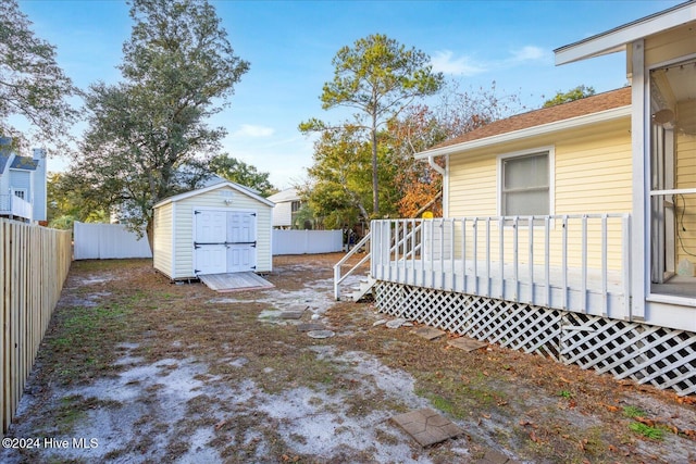 view of yard with a deck and a storage unit