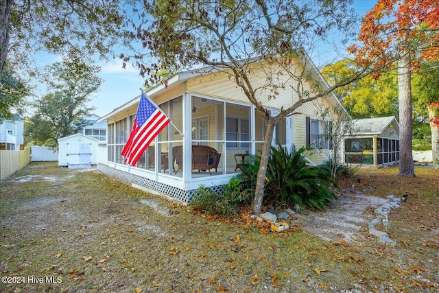 view of side of home featuring a shed and a sunroom