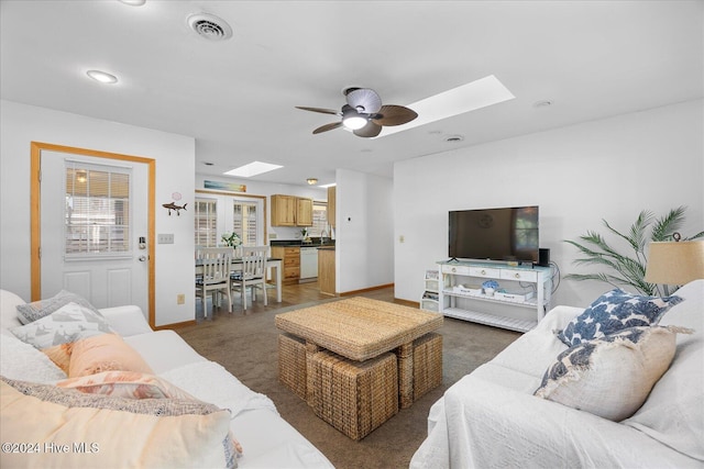 living room with a skylight and ceiling fan