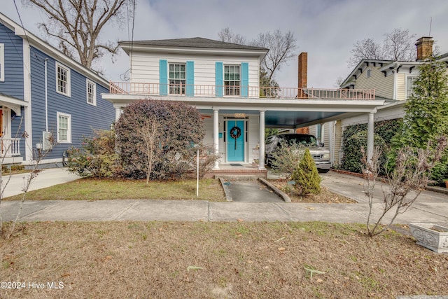 view of property featuring a front lawn and a carport