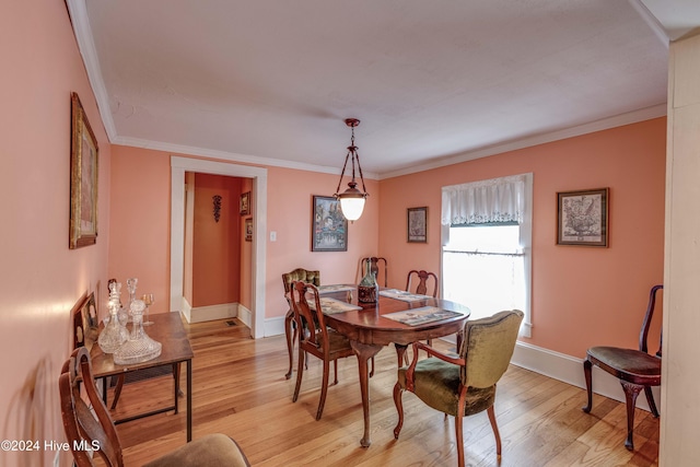 dining room featuring light wood-type flooring and ornamental molding