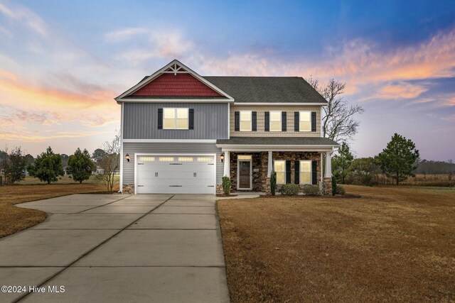 craftsman inspired home featuring a garage, a porch, and a front lawn