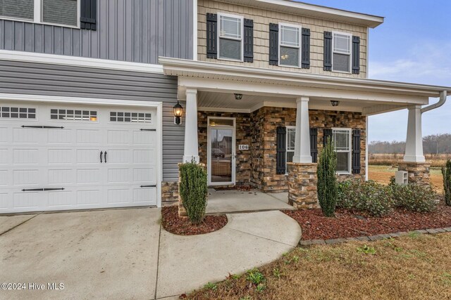 doorway to property featuring a garage and covered porch