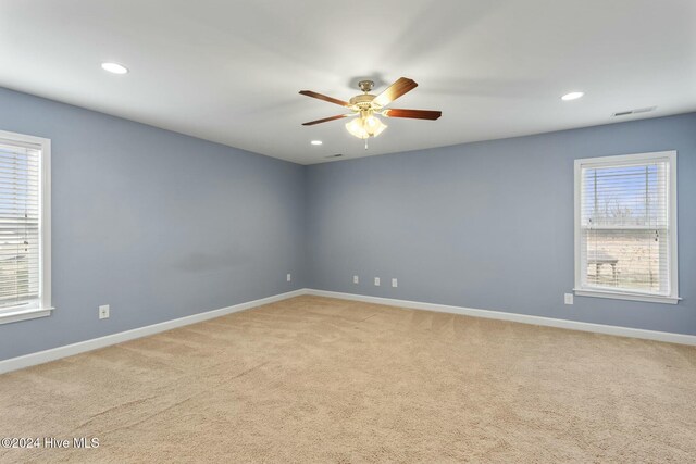 carpeted spare room featuring ceiling fan