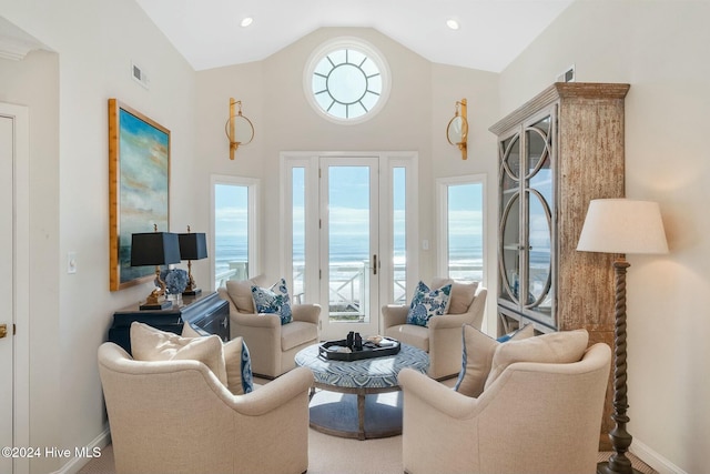 living room with a water view, lofted ceiling, and carpet floors