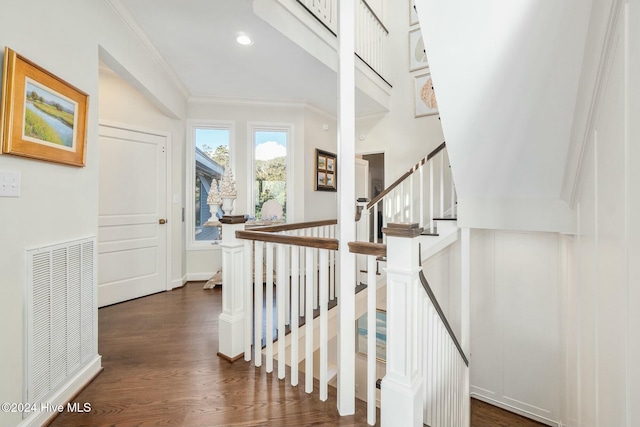 staircase featuring crown molding and wood-type flooring