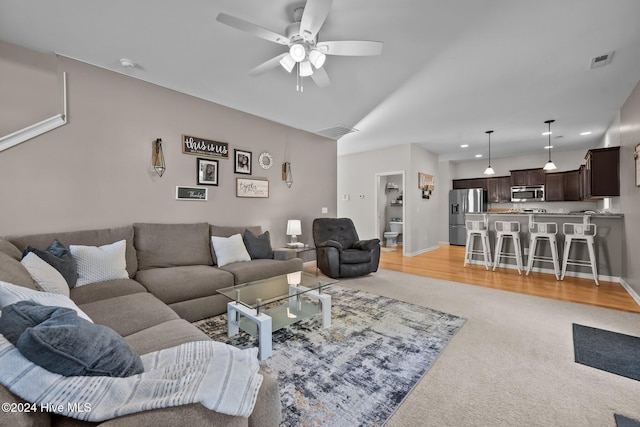 carpeted living room featuring ceiling fan