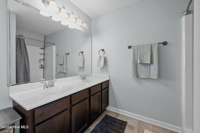 bathroom with tile patterned flooring, vanity, and walk in shower