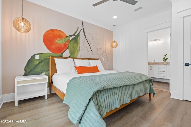 bedroom with hardwood / wood-style flooring, ensuite bath, ceiling fan, and ornamental molding