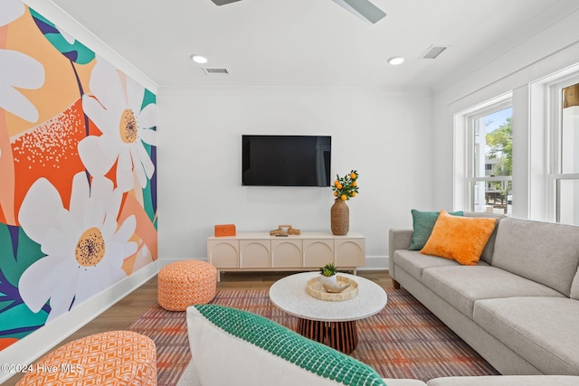 living room with wood-type flooring and ornamental molding