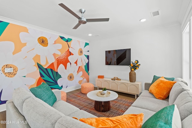 living room featuring wood-type flooring, ceiling fan, and crown molding