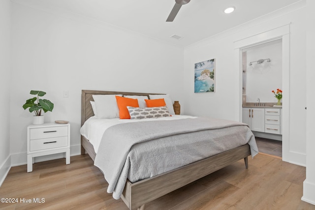 bedroom featuring ceiling fan, light hardwood / wood-style flooring, ensuite bathroom, and ornamental molding