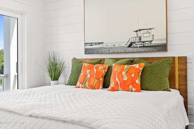 bedroom featuring wooden walls