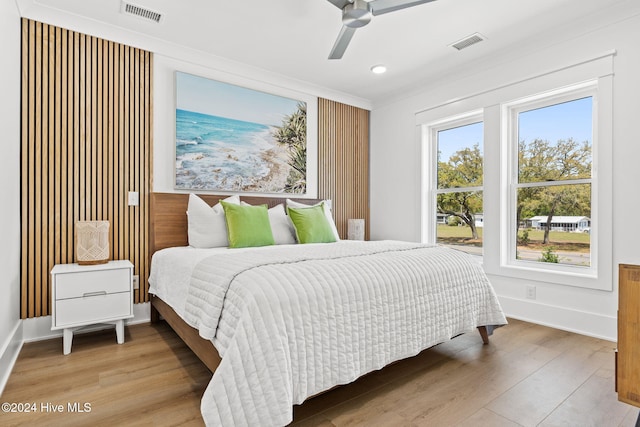 bedroom featuring hardwood / wood-style floors, ceiling fan, and ornamental molding