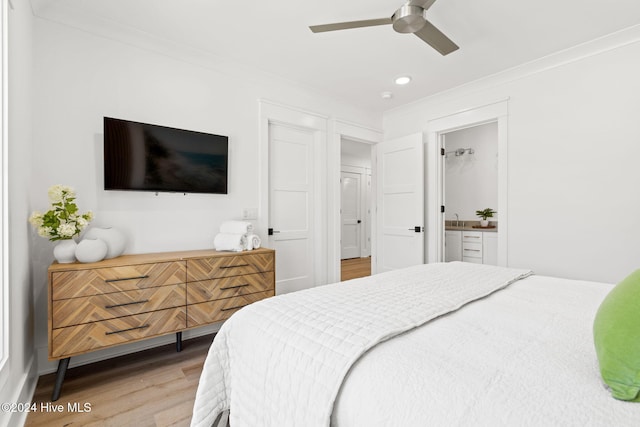 bedroom featuring light wood-type flooring, ensuite bathroom, ornamental molding, ceiling fan, and sink