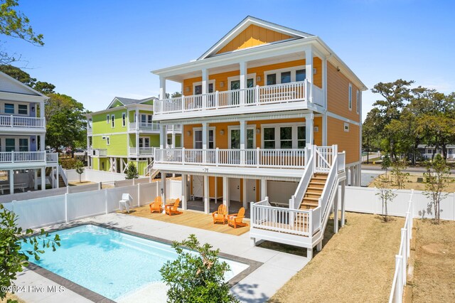 back of house featuring a balcony and a pool side deck