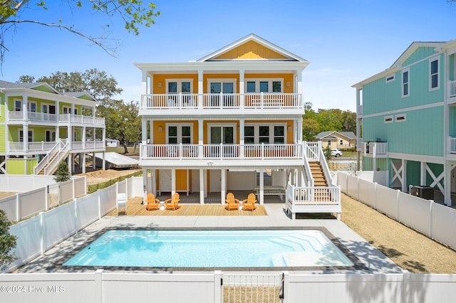 back of property with a swimming pool side deck and a balcony