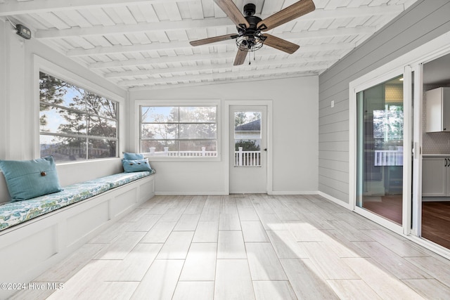 unfurnished sunroom featuring ceiling fan, lofted ceiling with beams, and wooden ceiling