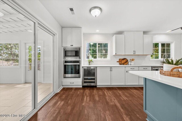 4 Emerald Ln, Pinehurst, NC 28374 - kitchen featuring stainless steel appliances, beverage cooler, light countertops, and dark wood-style flooring