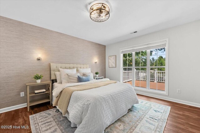 4 Emerald Ln, Pinehurst, NC 28374 - bedroom featuring an accent wall, baseboards, wallpapered walls, and wood finished floors