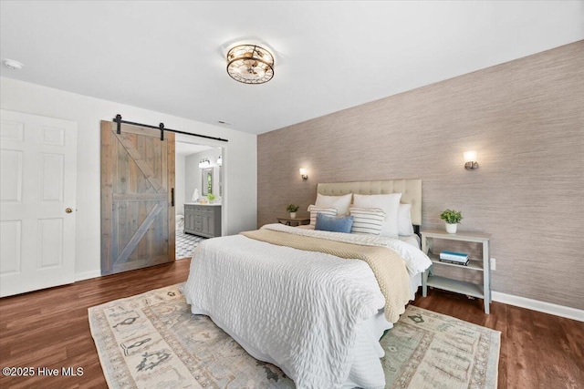 4 Emerald Ln, Pinehurst, NC 28374 - bedroom with a barn door, wallpapered walls, baseboards, an accent wall, and wood finished floors