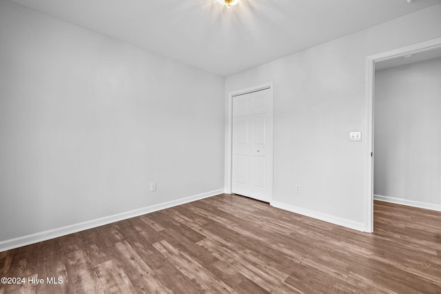 unfurnished bedroom featuring wood-type flooring and a closet