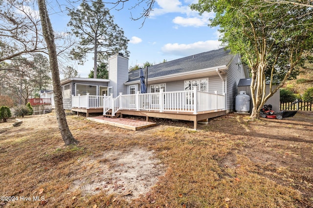 back of house featuring a wooden deck and a sunroom