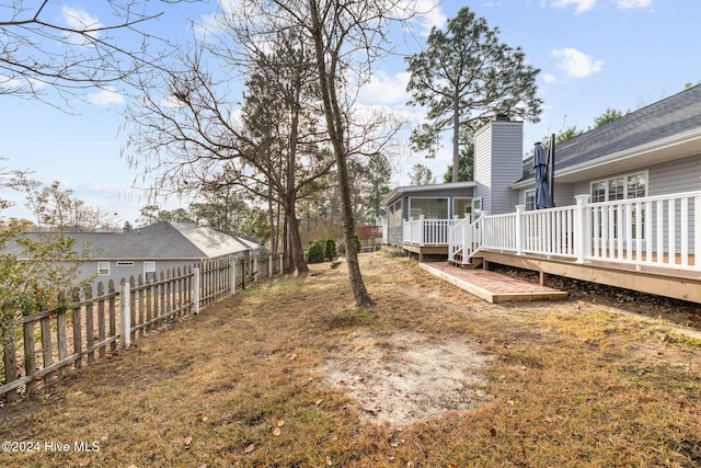 view of yard featuring a wooden deck and a sunroom