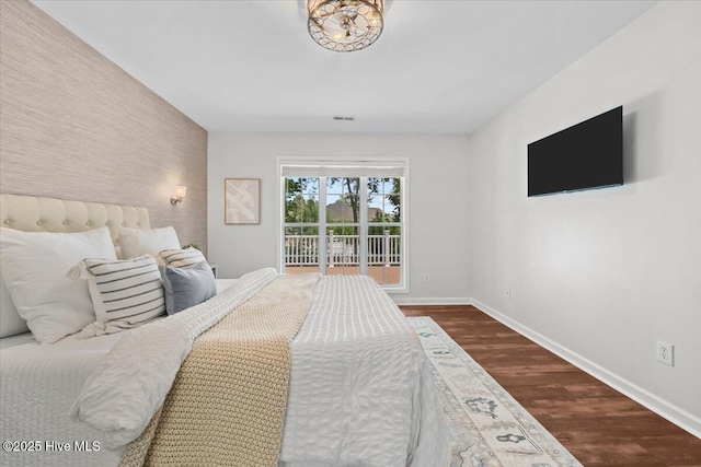 4 Emerald Ln, Pinehurst, NC 28374 - bedroom featuring baseboards, an accent wall, and dark wood-type flooring