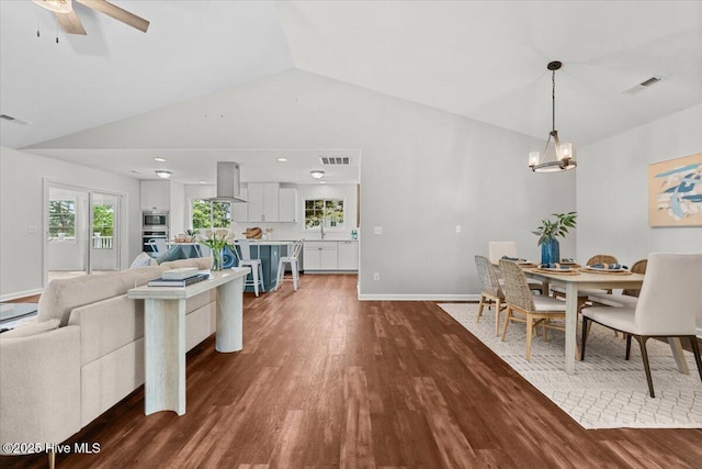 4 Emerald Ln, Pinehurst, NC 28374 - dining room featuring lofted ceiling, dark wood-type flooring, a chandelier, a ceiling fan, and baseboards