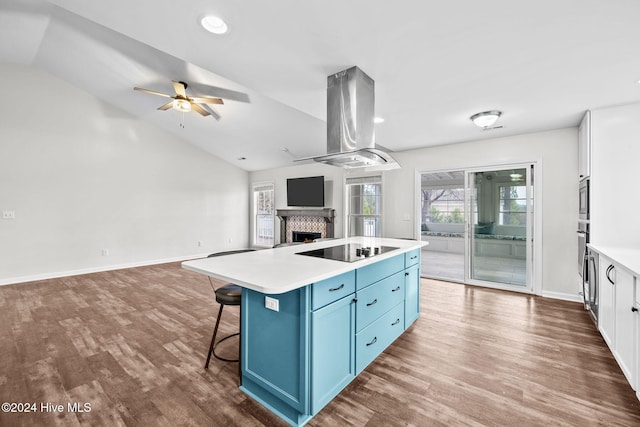 kitchen featuring blue cabinetry, appliances with stainless steel finishes, a center island, white cabinets, and island exhaust hood