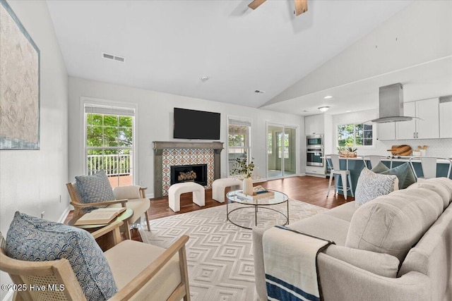 4 Emerald Ln, Pinehurst, NC 28374 - living room with lofted ceiling, plenty of natural light, light wood-style flooring, and a tiled fireplace
