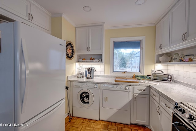 kitchen featuring stainless steel electric range oven, freestanding refrigerator, independent washer and dryer, and backsplash