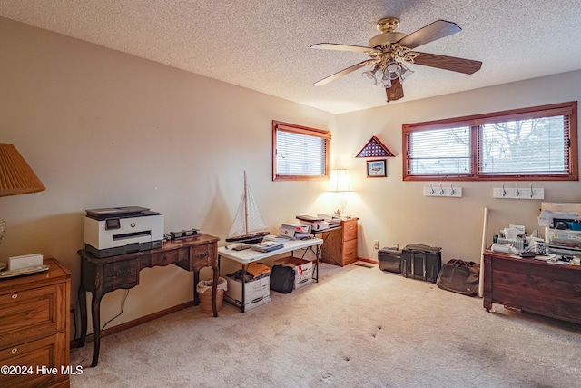 carpeted office featuring ceiling fan and a textured ceiling