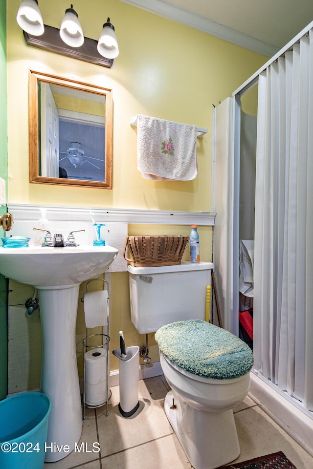 bathroom featuring sink, tile patterned flooring, ornamental molding, toilet, and walk in shower