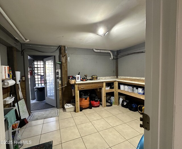 interior space with tile patterned flooring and a workshop area