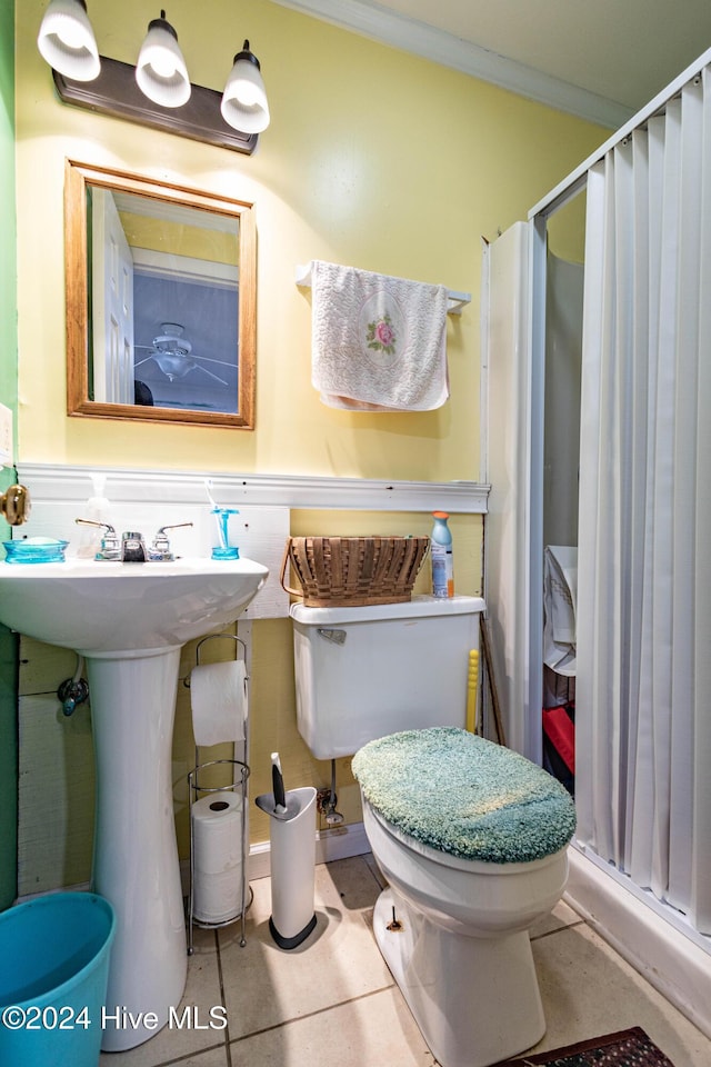 full bathroom with a shower stall, toilet, crown molding, and a sink